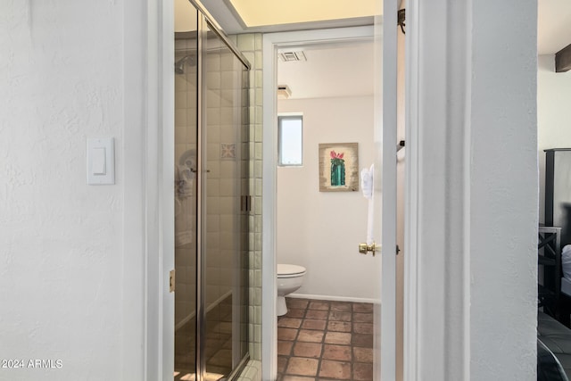 bathroom featuring an enclosed shower, toilet, and tile floors