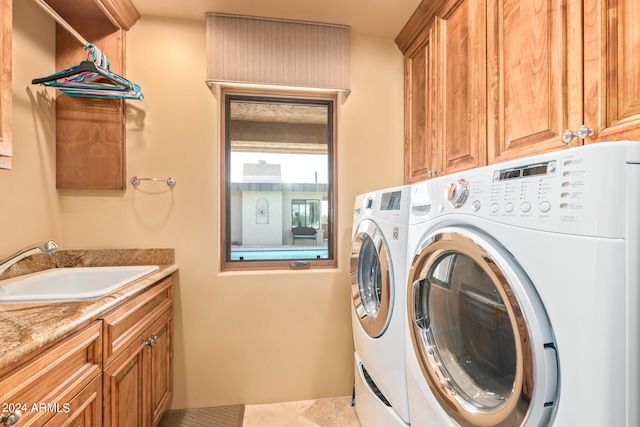 washroom featuring light tile floors, cabinets, washer and dryer, and sink