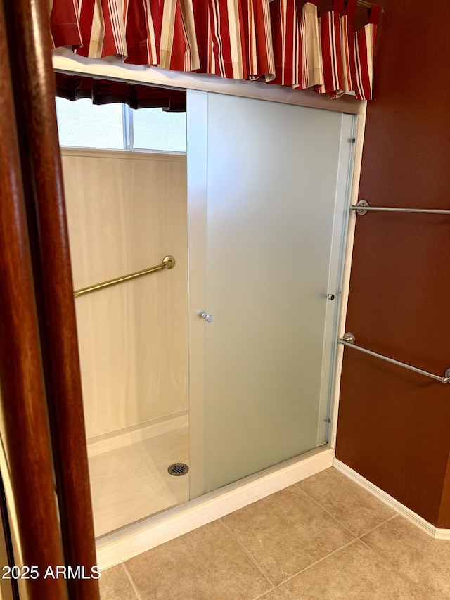 full bath featuring tile patterned flooring and a shower stall