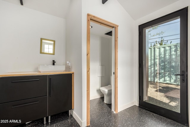 bathroom with lofted ceiling, vanity, a wealth of natural light, and toilet