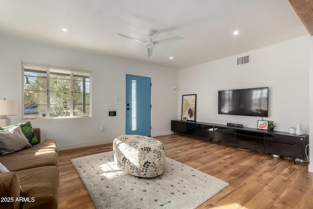 living room with wood-type flooring and ceiling fan