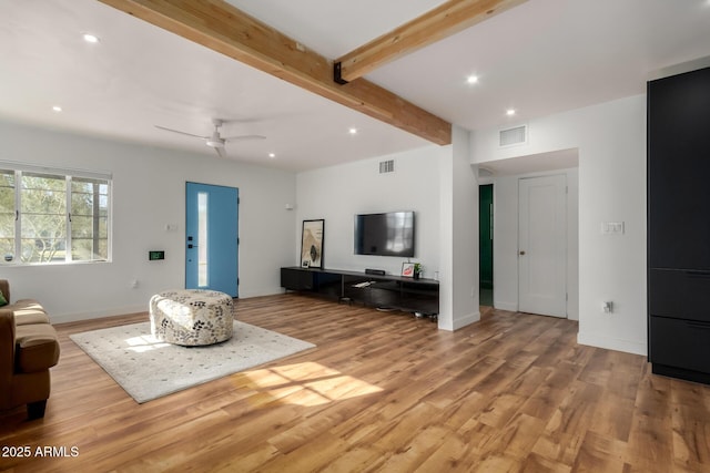 living room with beam ceiling, ceiling fan, and light wood-type flooring