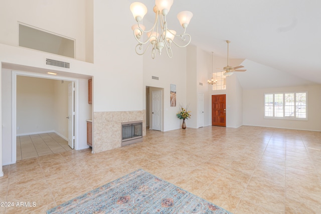 unfurnished living room featuring high vaulted ceiling, ceiling fan with notable chandelier, tile floors, and a tiled fireplace