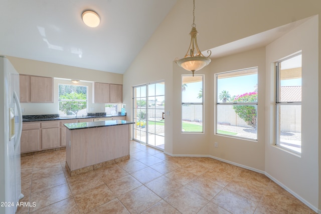 kitchen with decorative light fixtures, white fridge with ice dispenser, light brown cabinets, and a wealth of natural light