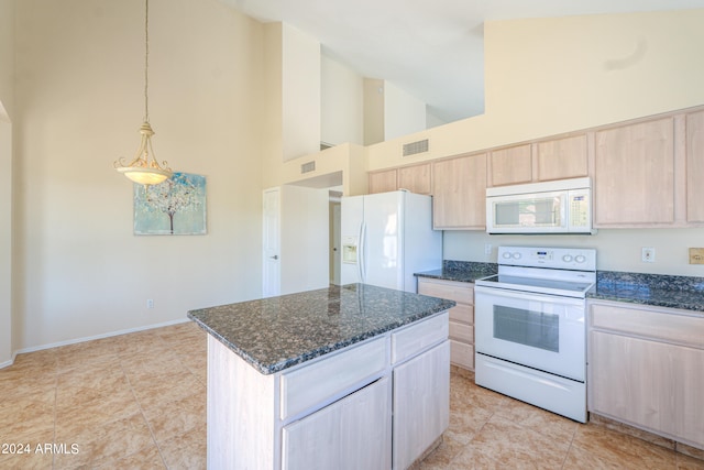 kitchen with decorative light fixtures, white appliances, a towering ceiling, light tile floors, and a kitchen island