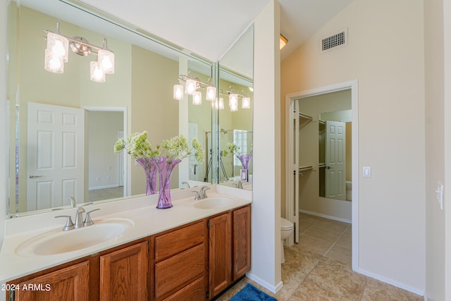 bathroom with lofted ceiling, toilet, tile floors, and dual vanity