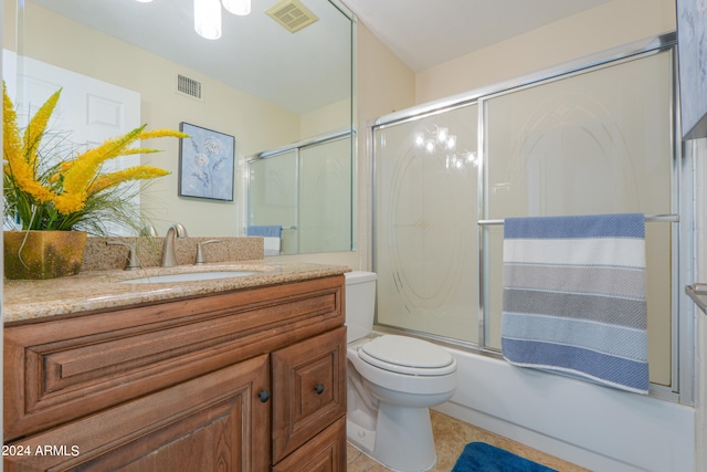 full bathroom featuring toilet, tile floors, vanity, and shower / bath combination with glass door