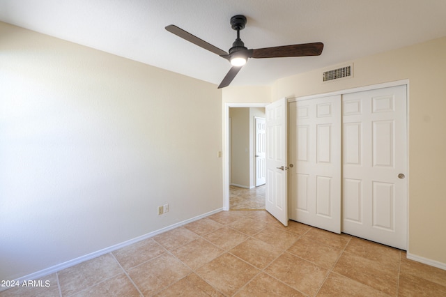 unfurnished bedroom with a closet, ceiling fan, and light tile flooring