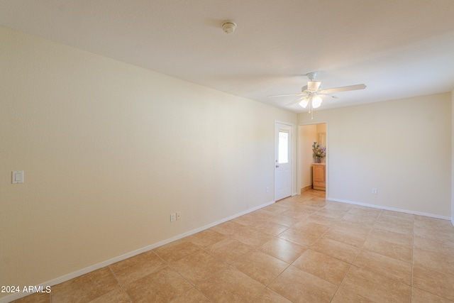 tiled spare room with ceiling fan