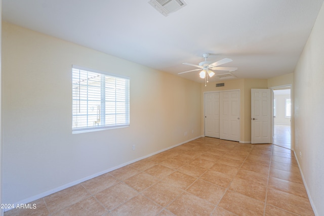 unfurnished room with ceiling fan and light tile flooring