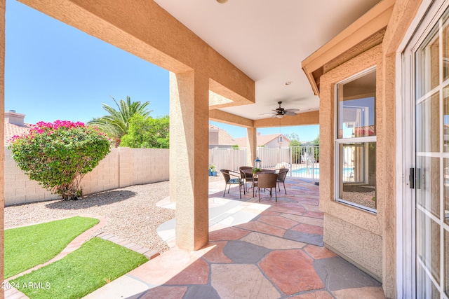 view of patio / terrace with ceiling fan and a fenced in pool