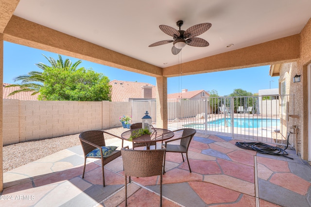 view of patio with ceiling fan and a fenced in pool