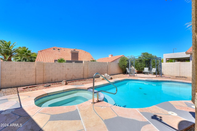 view of swimming pool featuring an in ground hot tub