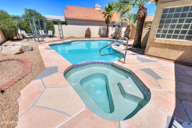 view of swimming pool featuring an in ground hot tub and a patio area