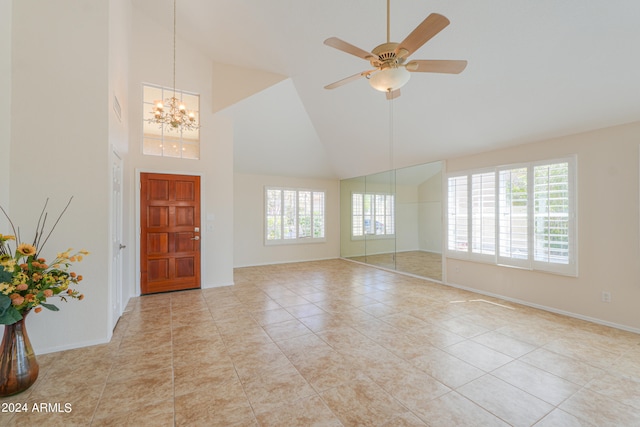 foyer featuring ceiling fan with notable chandelier, high vaulted ceiling, and light tile floors