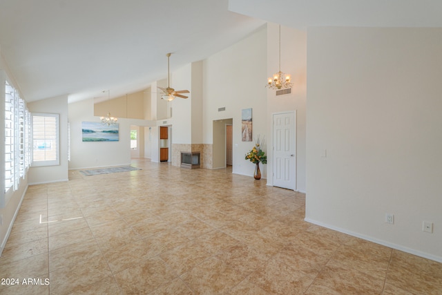 unfurnished living room featuring ceiling fan with notable chandelier, high vaulted ceiling, and light tile floors