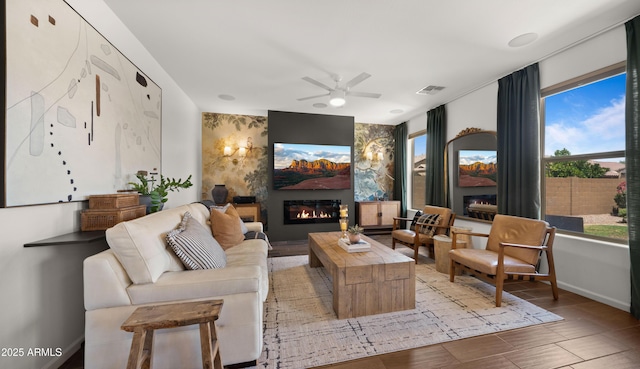 10224 E Talameer Ave, Mesa, AZ 85212 - living room featuring a glass covered fireplace, ceiling fan, and baseboards