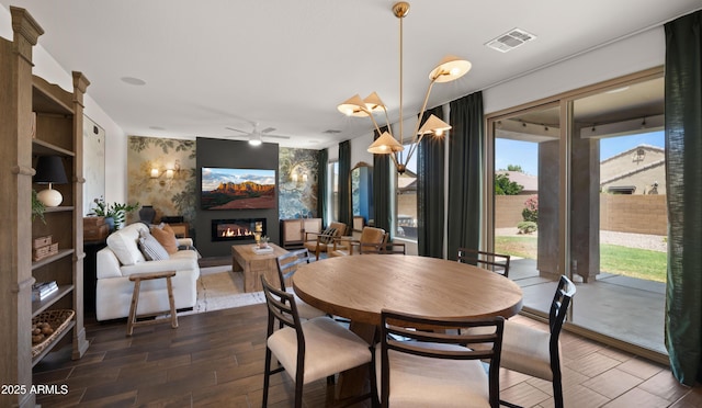 10224 E Talameer Ave, Mesa, AZ 85212 - dining room featuring a glass covered fireplace, dark wood-type flooring, and a ceiling fan