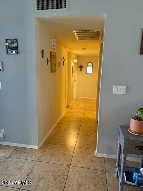 corridor with light tile patterned floors, baseboards, and visible vents