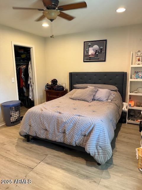 bedroom featuring recessed lighting, a ceiling fan, a spacious closet, and wood finished floors
