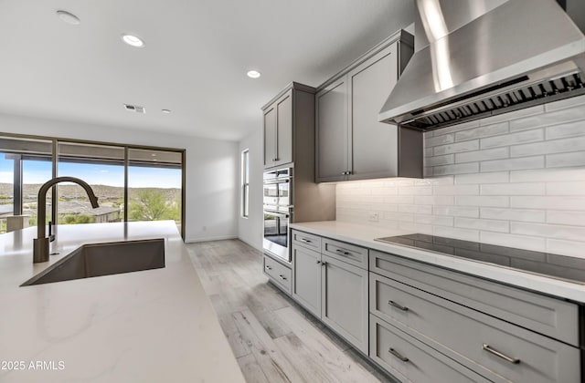 4128 Desert Moon Dr, Wickenburg, AZ 85390 - kitchen with wall chimney range hood, a sink, tasteful backsplash, recessed lighting, and gray cabinets