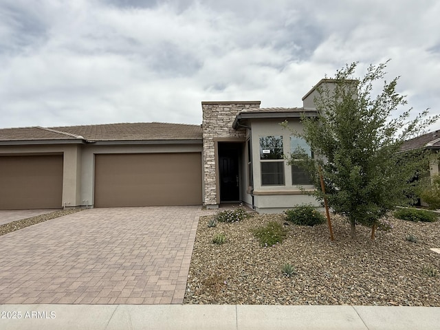 4128 Desert Moon Dr, Wickenburg, AZ 85390 - view of front of house with a garage, decorative driveway, stucco siding, and stone siding