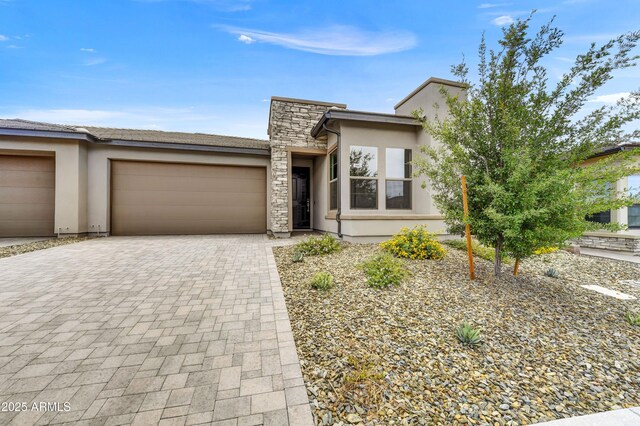4128 Desert Moon Dr, Wickenburg, AZ 85390 - view of front facade with an attached garage, decorative driveway, stucco siding, and stone siding