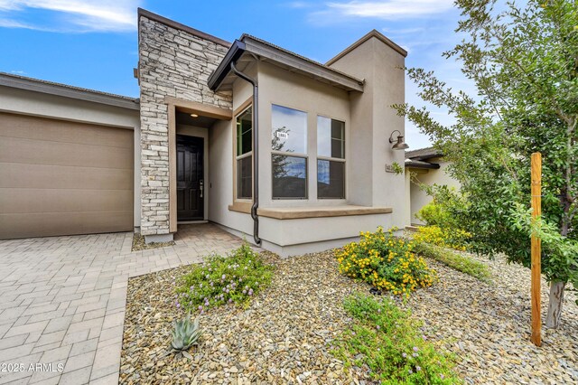 4128 Desert Moon Dr, Wickenburg, AZ 85390 - view of front of house featuring stone siding, an attached garage, and stucco siding