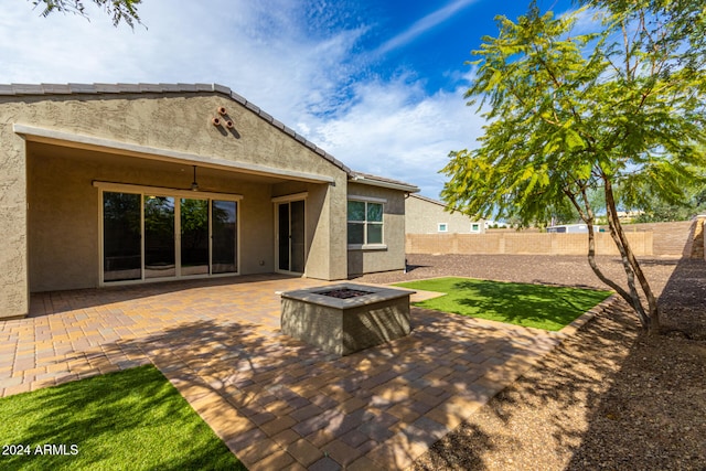 back of house featuring an outdoor fire pit, a patio, and ceiling fan