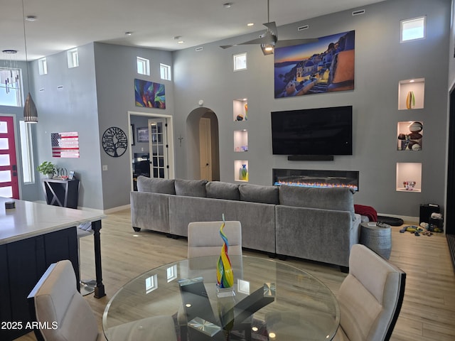 living room with light hardwood / wood-style floors and a high ceiling