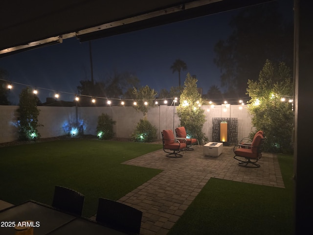 yard at twilight with a patio and an outdoor fire pit