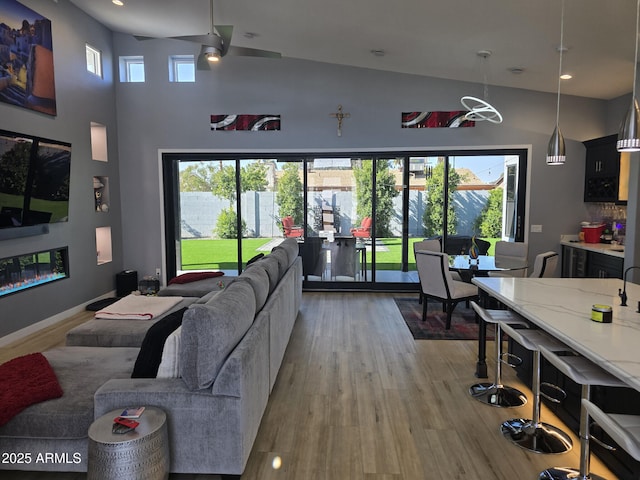 living room featuring ceiling fan, light hardwood / wood-style floors, and a healthy amount of sunlight