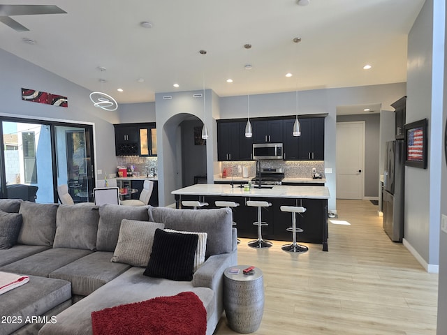 living room with vaulted ceiling and light wood-type flooring