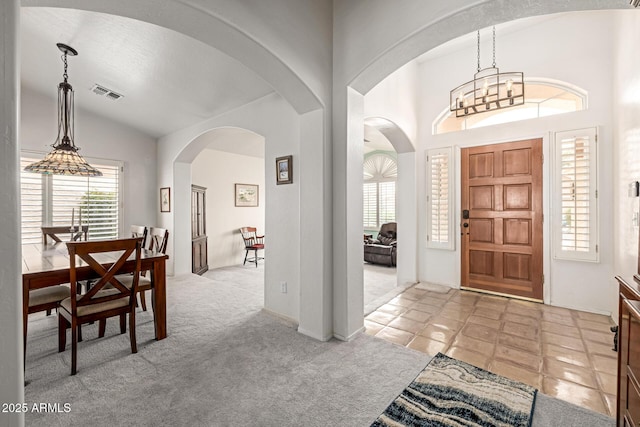 1146 W Sea Fog Dr, Gilbert, AZ 85233 - carpeted entryway featuring vaulted ceiling, arched walkways, and a chandelier