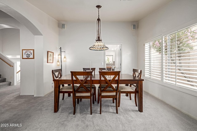 1146 W Sea Fog Dr, Gilbert, AZ 85233 - dining area featuring light carpet, stairs, and arched walkways