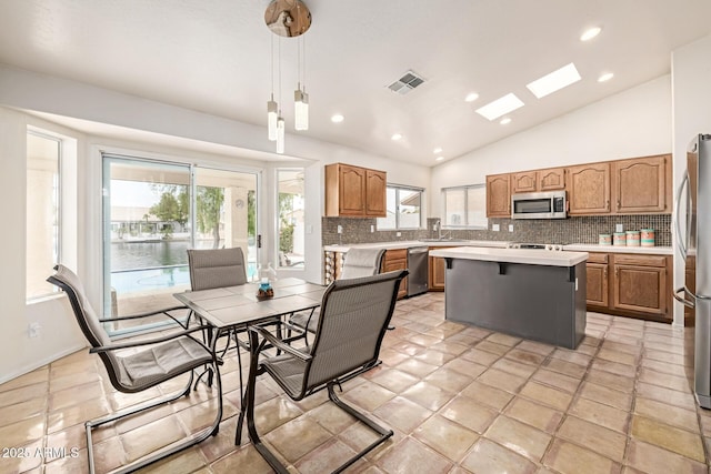 1146 W Sea Fog Dr, Gilbert, AZ 85233 - kitchen featuring stainless steel appliances, vaulted ceiling, light countertops, backsplash, and a kitchen island