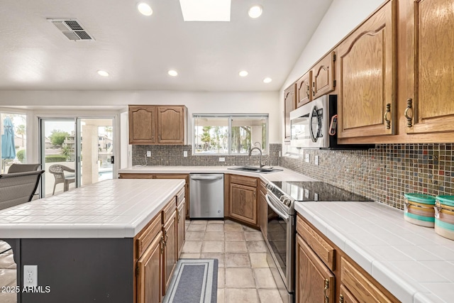 1146 W Sea Fog Dr, Gilbert, AZ 85233 - kitchen with appliances with stainless steel finishes, tile counters, tasteful backsplash, a sink, and recessed lighting