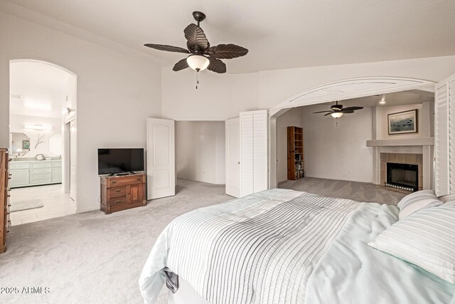 1146 W Sea Fog Dr, Gilbert, AZ 85233 - bedroom with arched walkways, light carpet, ceiling fan, and a fireplace
