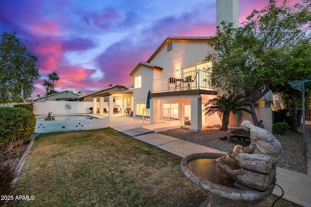 1146 W Sea Fog Dr, Gilbert, AZ 85233 - back of house at dusk with a balcony, stucco siding, a fire pit, a patio, and a tile roof