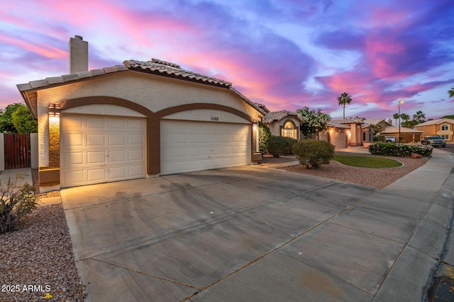 1146 W Sea Fog Dr, Gilbert, AZ 85233 - mediterranean / spanish house with a garage, concrete driveway, stucco siding, a tile roof, and a chimney