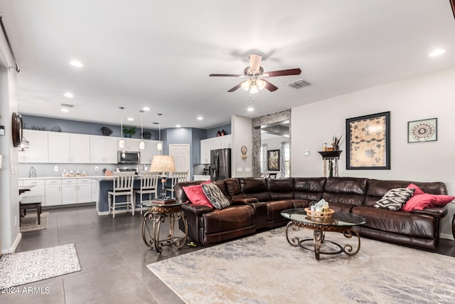 living room featuring ceiling fan and sink