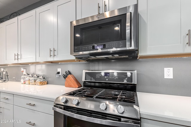 kitchen with appliances with stainless steel finishes, backsplash, and white cabinetry