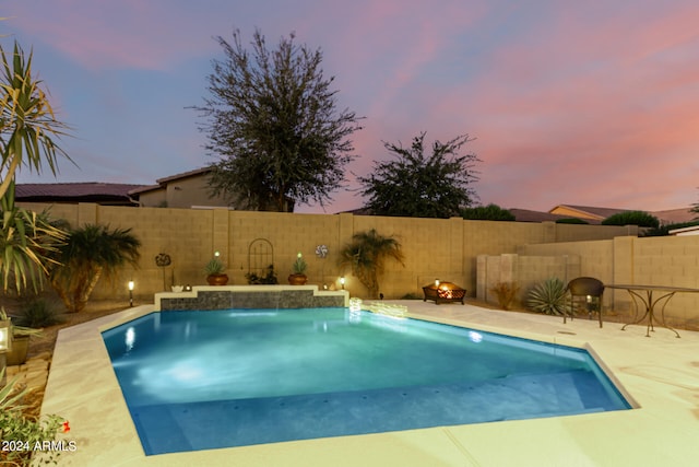 pool at dusk with pool water feature