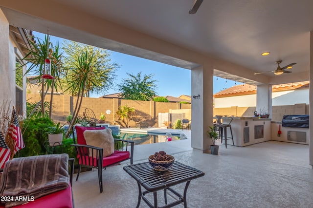 view of patio / terrace featuring ceiling fan, grilling area, a fenced in pool, and a bar