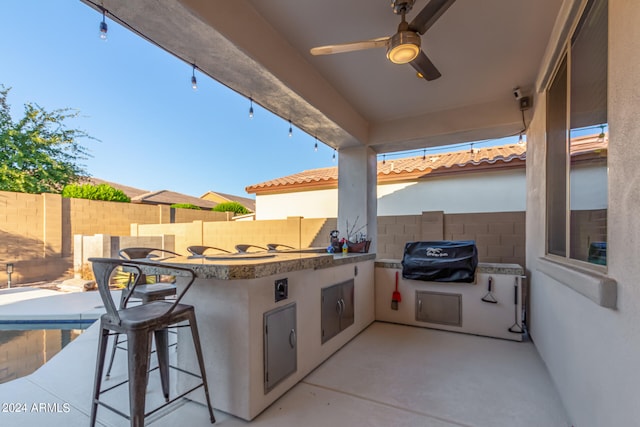 view of patio / terrace featuring a bar, area for grilling, ceiling fan, and a grill