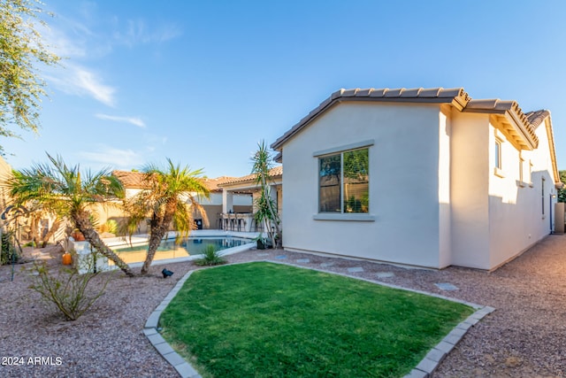 rear view of house featuring a patio and a lawn