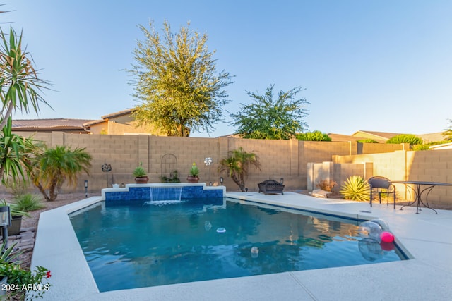 view of swimming pool with pool water feature and a patio area