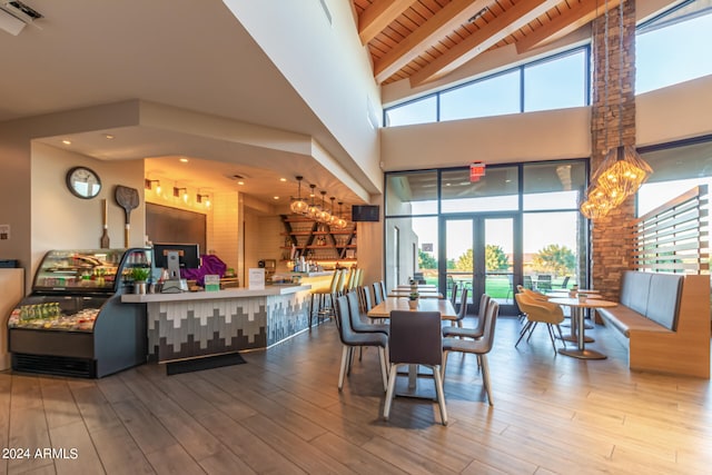 dining area with high vaulted ceiling, a wealth of natural light, and wood-type flooring