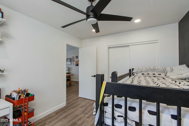 bedroom with light hardwood / wood-style flooring, a closet, and ceiling fan