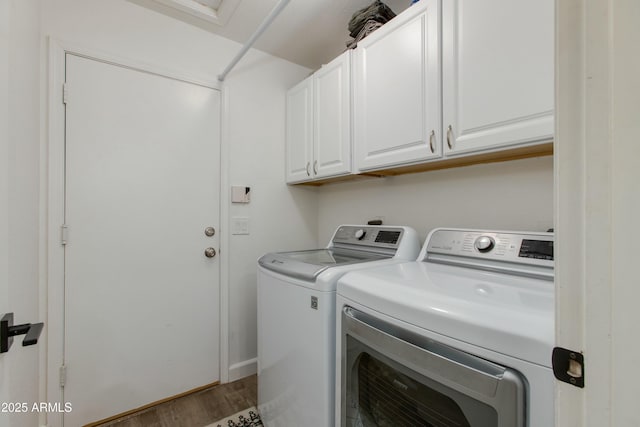 laundry room with cabinets, hardwood / wood-style floors, and washing machine and clothes dryer